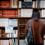 Woman browsing books at a library in Nagano, Japan. Explore knowledge and literature.