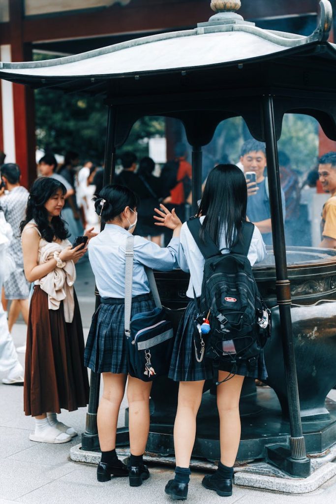 Students in school uniforms interacting at a cultural site outdoors.