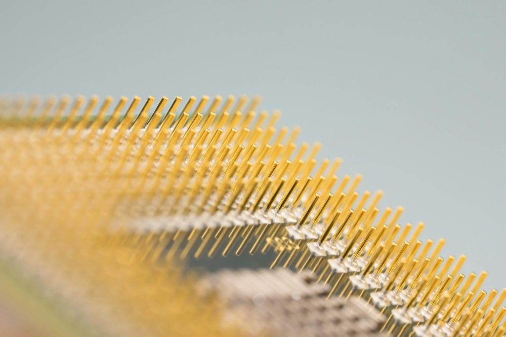 Detailed close-up of gold CPU pins, showcasing technology and design on a circuit board.