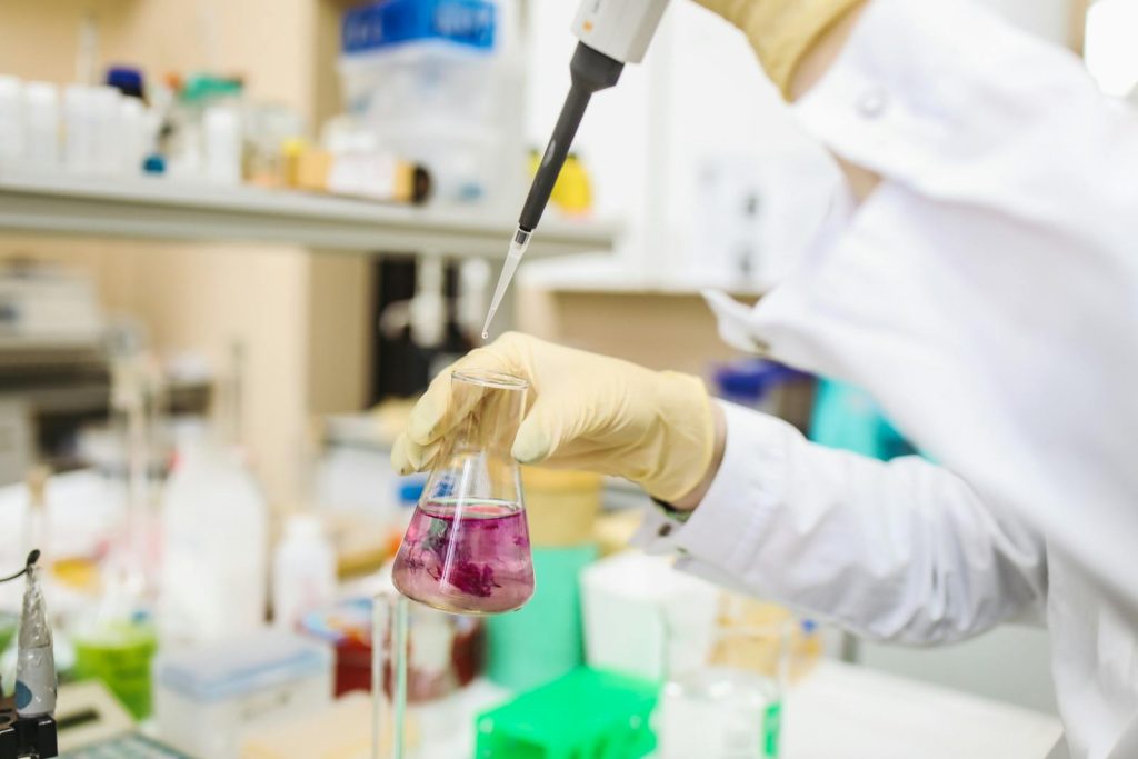 Scientist using a pipette for chemical analysis in a modern laboratory.