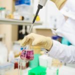 Scientist using a pipette for chemical analysis in a modern laboratory.