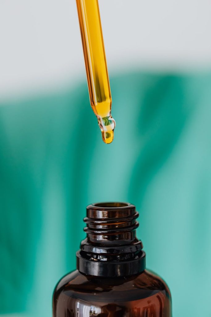 Detailed view of an amber glass bottle and dropper used in laboratory or medical setting, illustrating chemical experimentation.