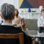 A therapist leads a couple's therapy session in a modern office setting.