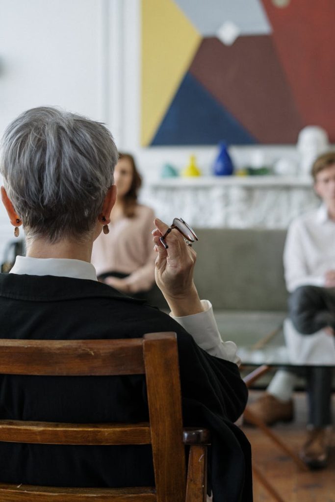 A therapist leads a couple's therapy session in a modern office setting.