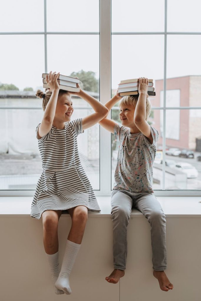 Two happy children playing with books, embodying the joy of learning together.