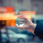 A crystal ball reflecting a vibrant city scene, with blurred lights and cars in Toronto.