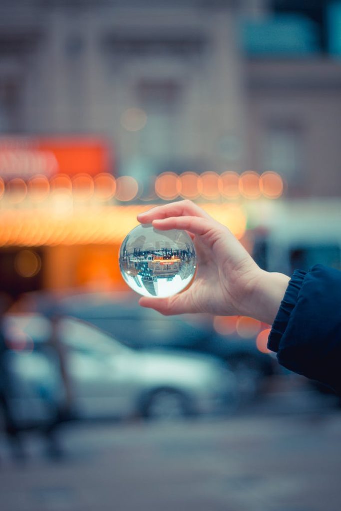 A crystal ball reflecting a vibrant city scene, with blurred lights and cars in Toronto.