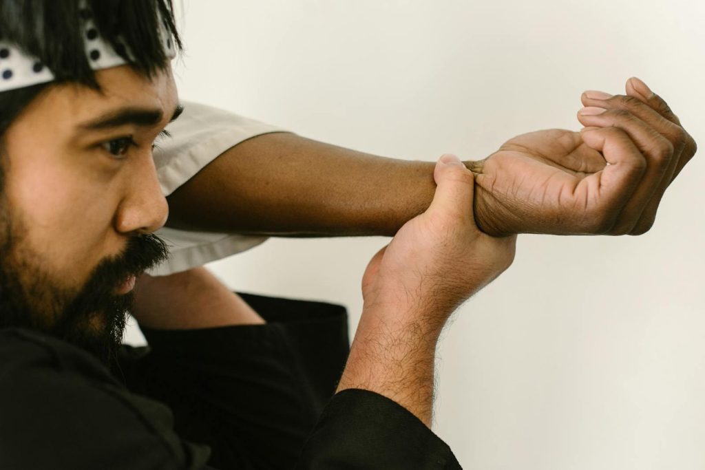 Two martial artists practicing grappling techniques in a dojo setting. Focus on self-defense and training.