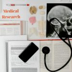 Flat lay of medical research materials with a stethoscope and anatomical models.